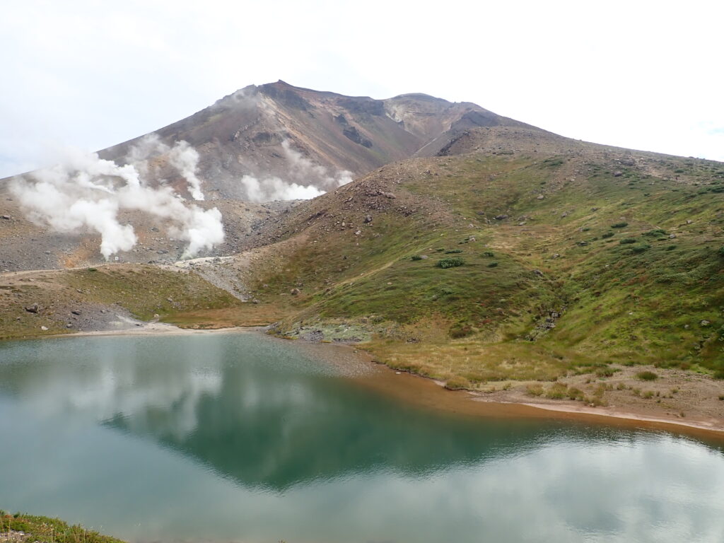 薄っすらと曇っていますが風もなく、姿見の池が水鏡となり旭岳を映しています。